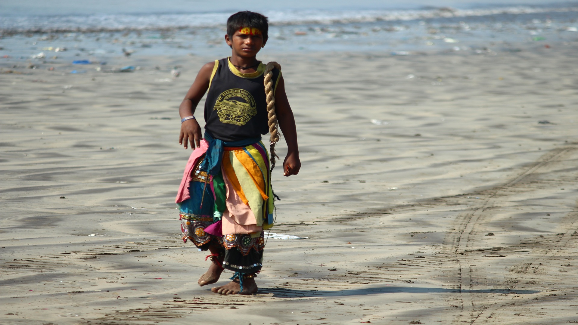 a poor boy wearing colourful cloths, he earns by hearting himself to entertian us